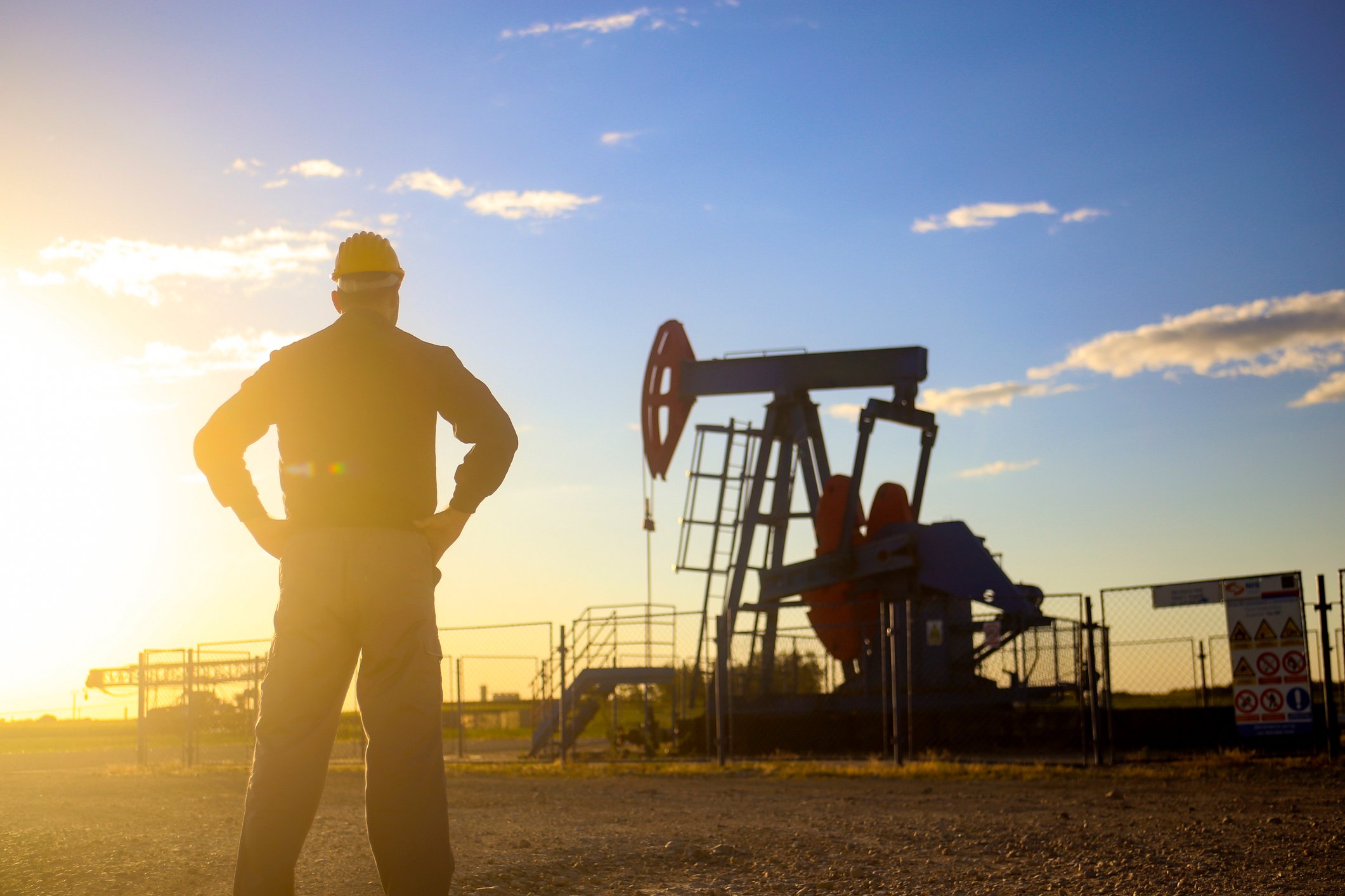 Oil industry worker working oil field sundown (Meidum Resolution)